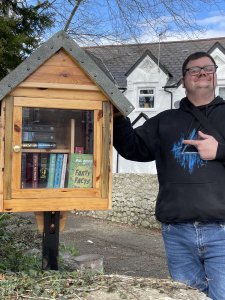 A person we support standing with the pop up library